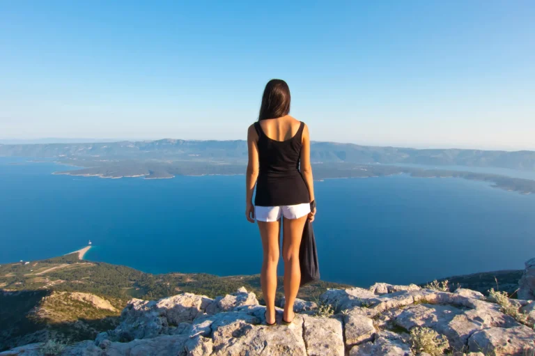 young woman looking panorama on brac highest peak, amazing view