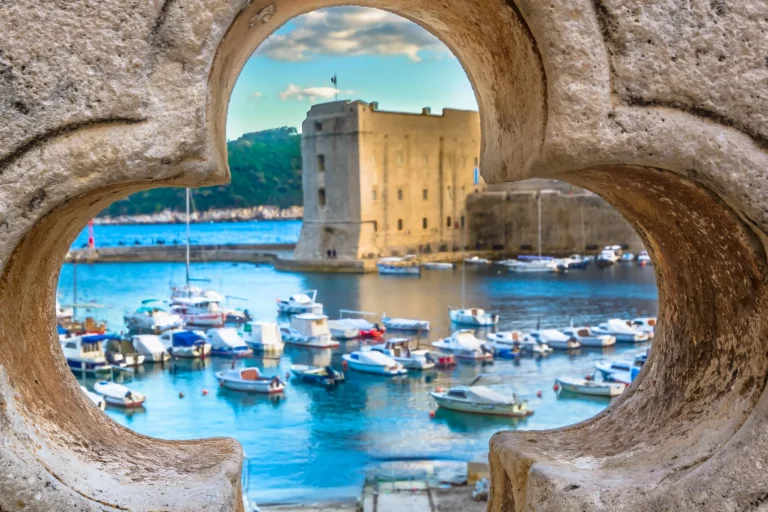 Dubrovnik scenery. / Old stone hole with Dubrovnik scenery in background, croatian travel places.